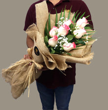 Two-tone pink roses in jute wrapping, front view