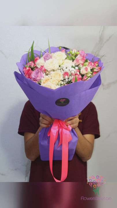 Pink and cream roses and blooms in purple wrapping