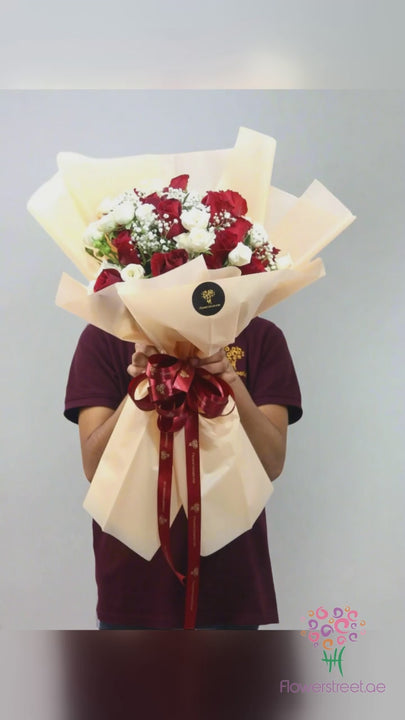Red and white roses with baby's breath in cream wrapping