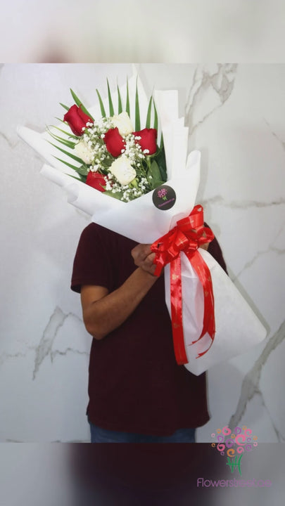 Red and white roses with baby's breath in white wrapping