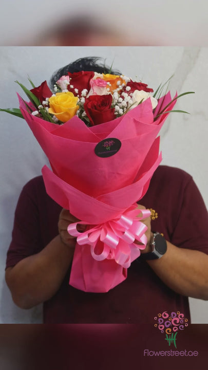 Round bouquet of mixed roses in bright pink wrapping