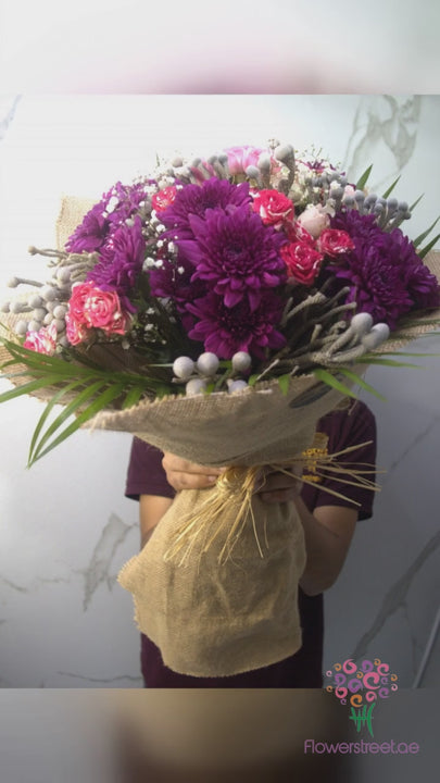 Magenta and purple chrysanthemums in natural jute wrapping