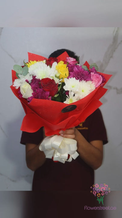 Mixed white, yellow and magenta chrysanthemums in red wrapping
