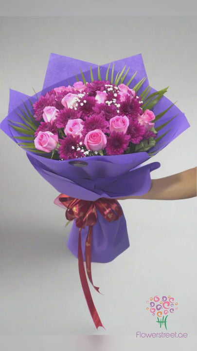 Pink roses and magenta purple blooms in purple wrapping