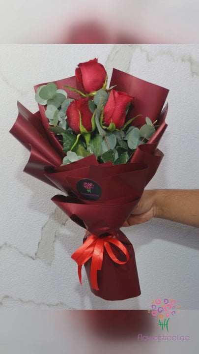 Three red roses with eucalyptus bouquet
