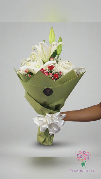 White lilies with red and white roses in sage green wrapping