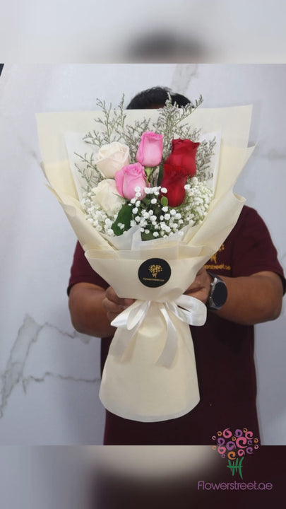 Pink, white and red roses with baby's breath in cream wrapping