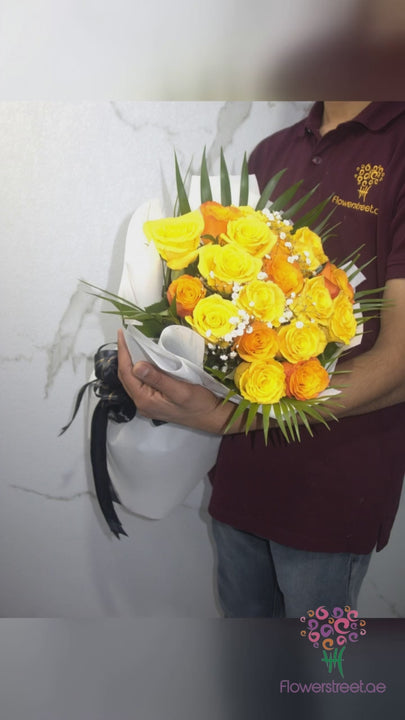 Twenty yellow and orange roses with baby's breath in white wrapping