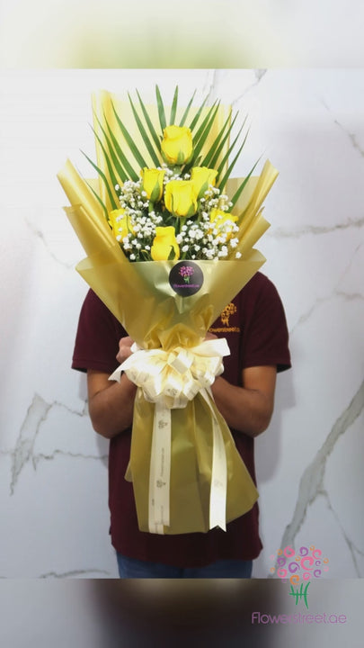 Yellow roses with baby's breath in yellow wrapping