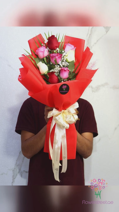Eight mixed red, pink and white roses in bright red wrapping
