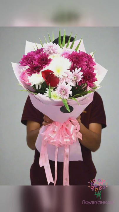 Pink and magenta chrysanthemums with white blooms in pink wrapping