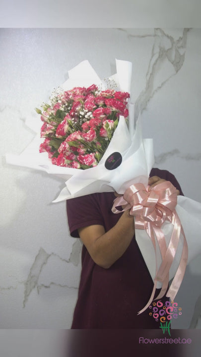 Two-tone pink and red spray roses in white wrapping