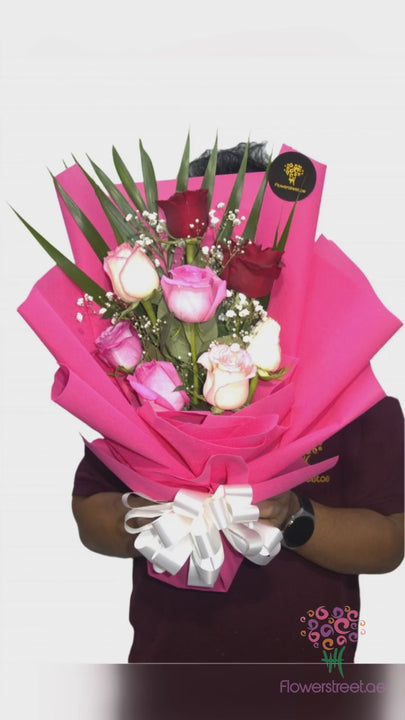 Eight mixed roses with baby's breath in bright pink wrapping