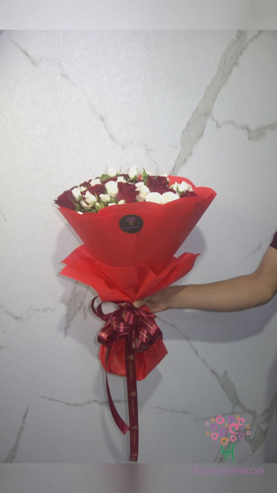 Red roses and white spray roses in bright red wrapping